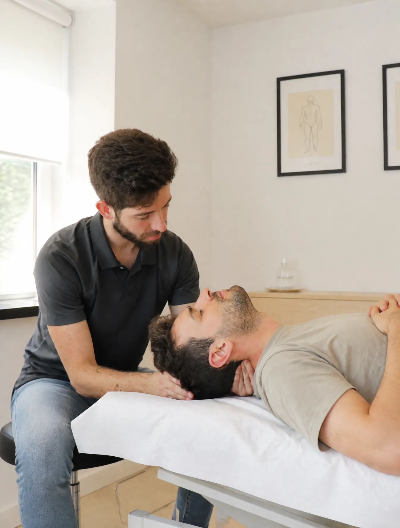 Fisioterapeuta tratando a un paciente en la camilla de Physeo Clinic, Terrassa